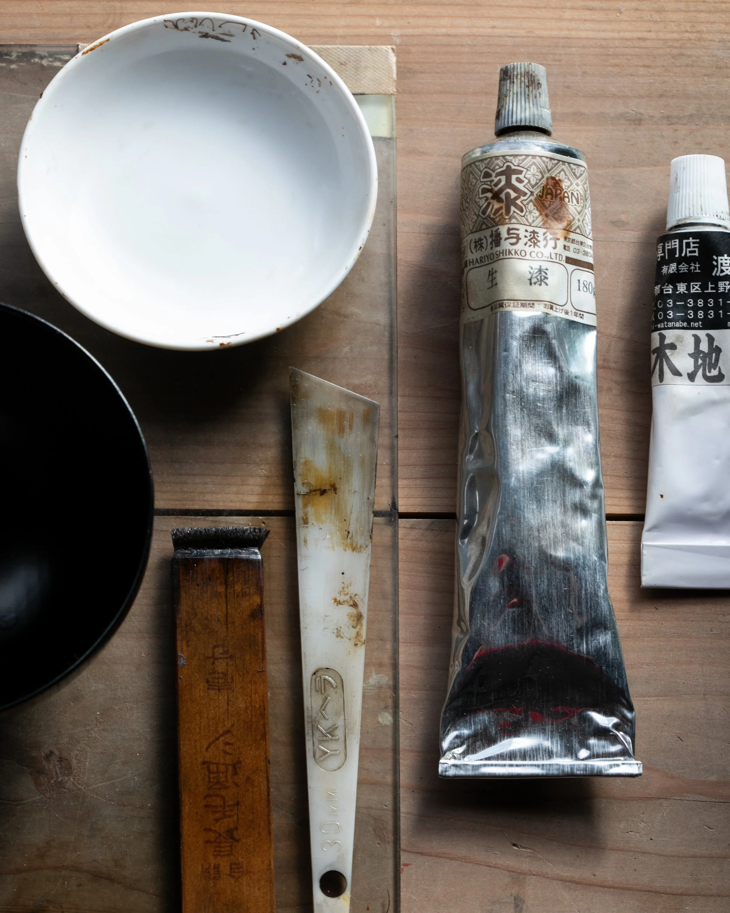The bowls, spatulas and tubes of an urushi artist's bench
